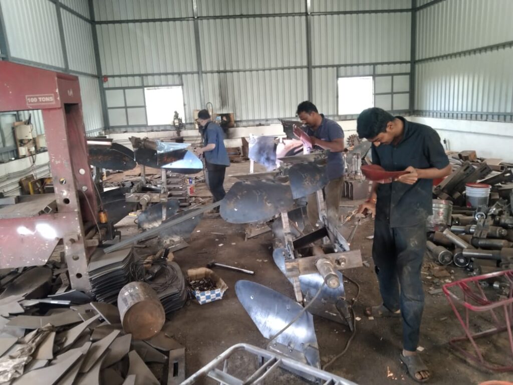 "Workshop worker at Shri Sai Ganesh Agro Industries assembling agricultural machinery"